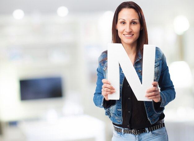 Smiling woman in denim jacket with the letter "n"