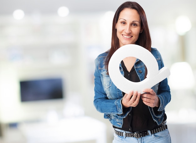 Smiling woman in denim jacket with the letter "q"
