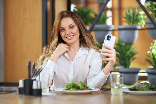 현대 전화에 selfie 하 고 웃는 여자