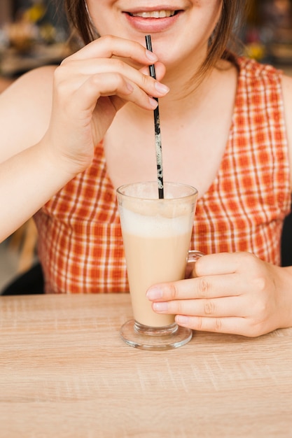 Donna sorridente che beve caffè latte al self-service