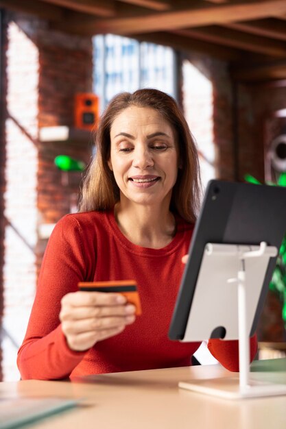 Smiling woman entering her credit card digits to confirm a money transfer
