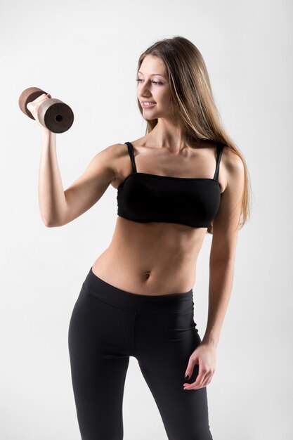 Smiling woman exercising with dumbbell