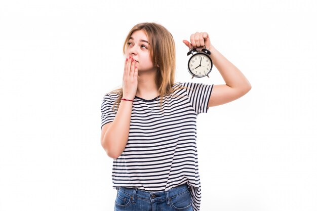 Smiling woman in eyeglasses holding alarm clock