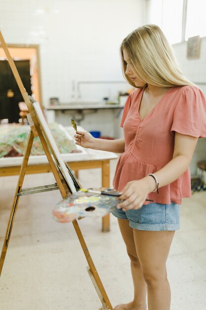 작업 공간에서 웃는 여자 여성 예술가 그림 작품