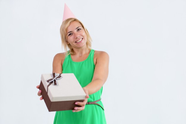 Smiling woman giving gift box to viewer