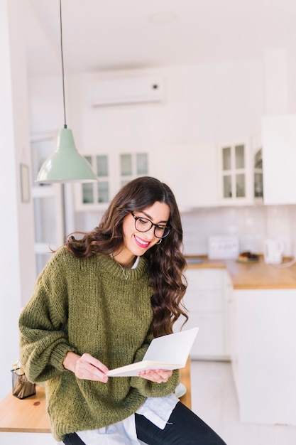 Foto gratuita donna sorridente in occhiali da lettura libro