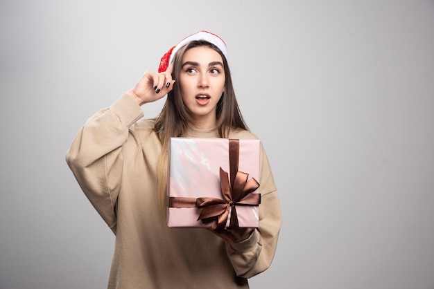 Smiling woman holding a box of Christmas present.