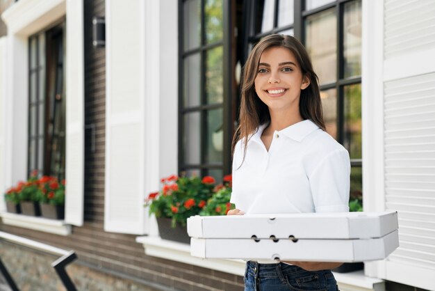 ピザの箱を保持している笑顔の女性