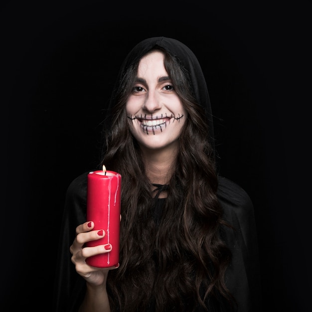 Smiling woman holding burning candle