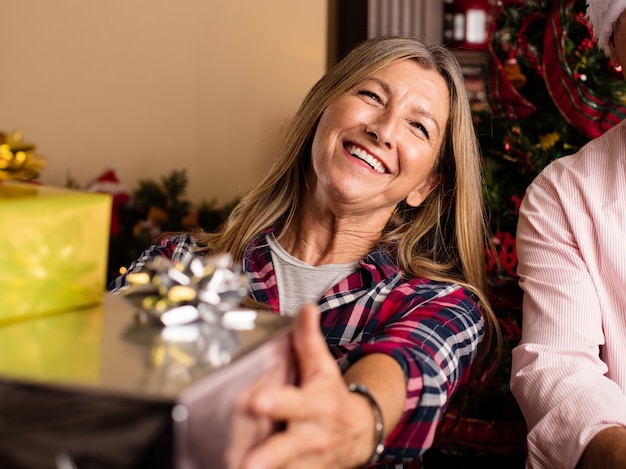 Free photo smiling woman holding christmas gifts