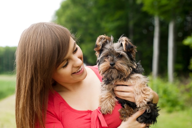 Smiling woman holding cute puppy
