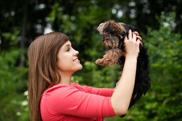 Smiling woman holding cute puppy