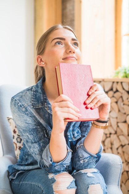 Free photo smiling woman holding hardcover book