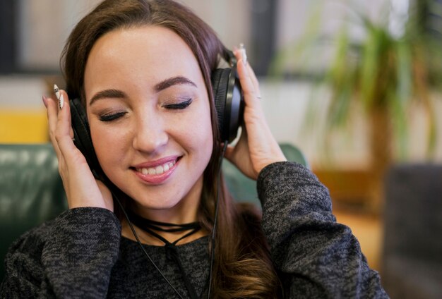 Smiling woman holding headphones on head