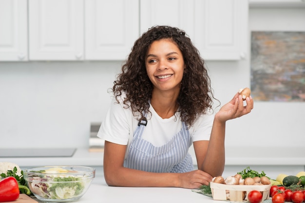 Foto gratuita donna sorridente che tiene una piccola patata