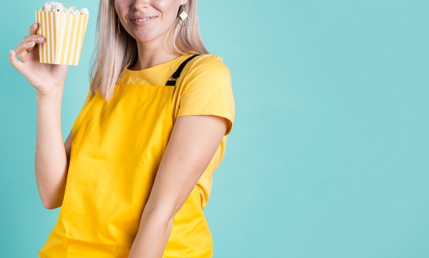 Spazio sorridente della copia del popcorn della tenuta della donna