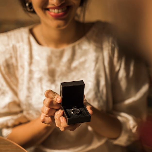 Foto gratuita donna sorridente che tiene scatola attuale con anello