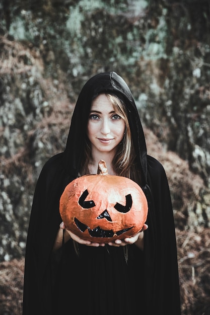 Foto gratuita zucca sorridente della tenuta della donna in parco