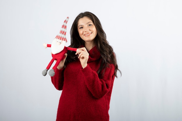 サンタクロースのぬいぐるみを手に持って笑顔の女性。