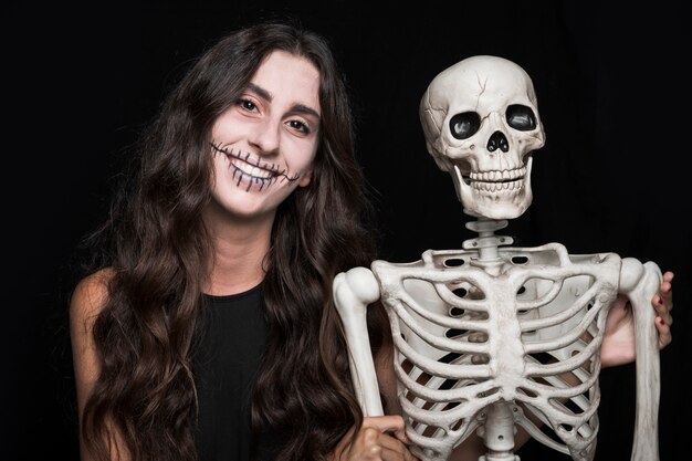 Smiling woman holding skeleton