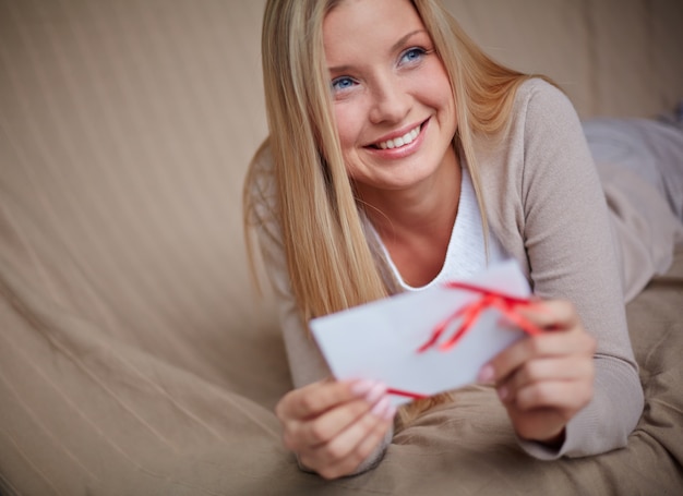 Free photo smiling woman holding a special card