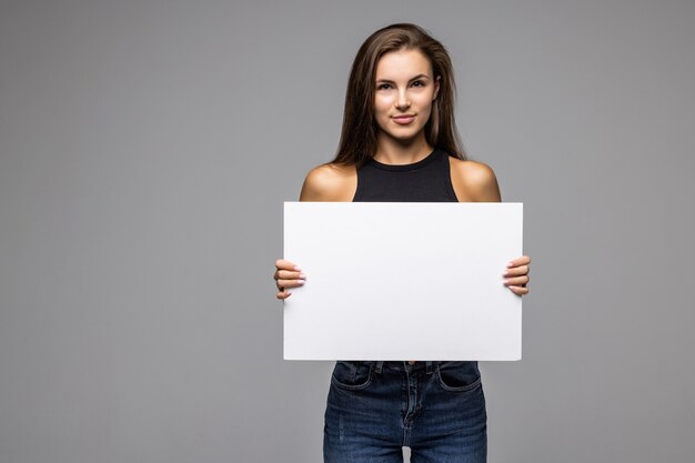 Smiling woman holding white banner isolated gray studio back.