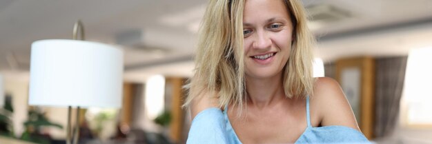 Smiling woman holds smartphone and looks at screen correspondence and mail viewing concept