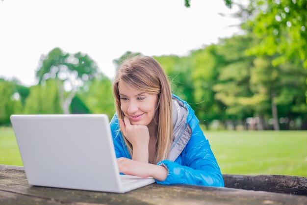 笑顔の女の子は、コンピュータの屋外で、大学のpで働いています