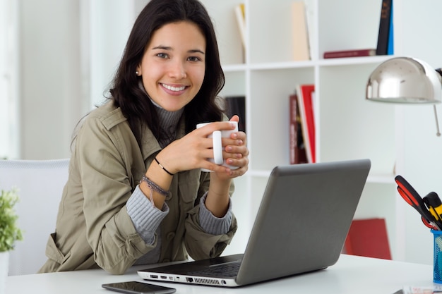 Donna sorridente a un computer portatile