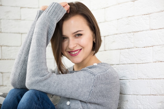 Foto gratuita donna sorridente che si appoggia sulla parete