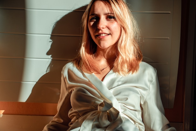 Smiling woman leaning on wall