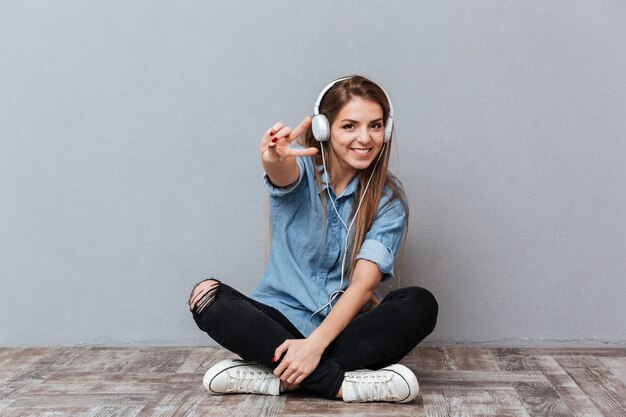 Smiling Woman listening music on the floor