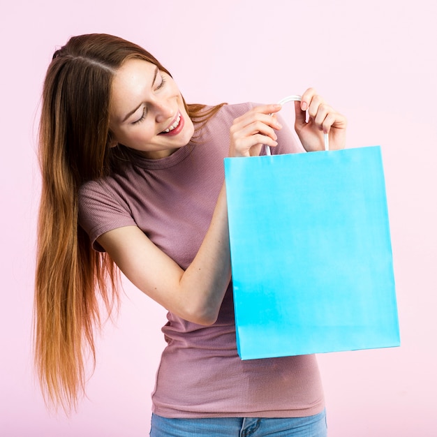 Smiling woman looking at blue paper bag