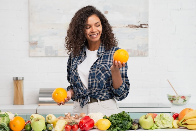 Smiling woman looking at delicious orange