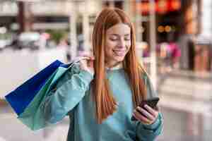 Foto gratuita donna sorridente che osserva sul telefono