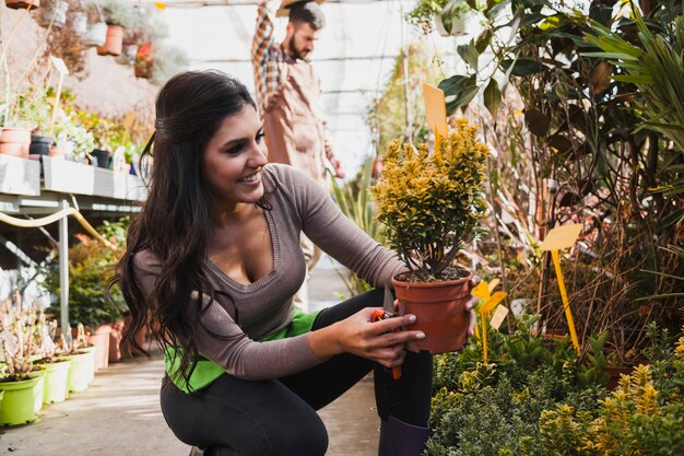 鉢植えの花を見る笑顔の女性