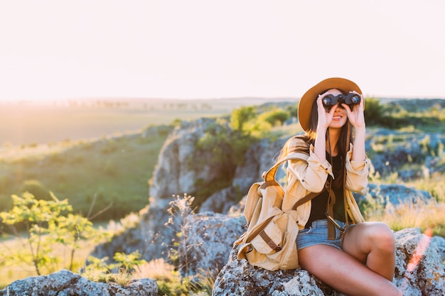 Foto gratuita donna sorridente che osserva tramite binoculare