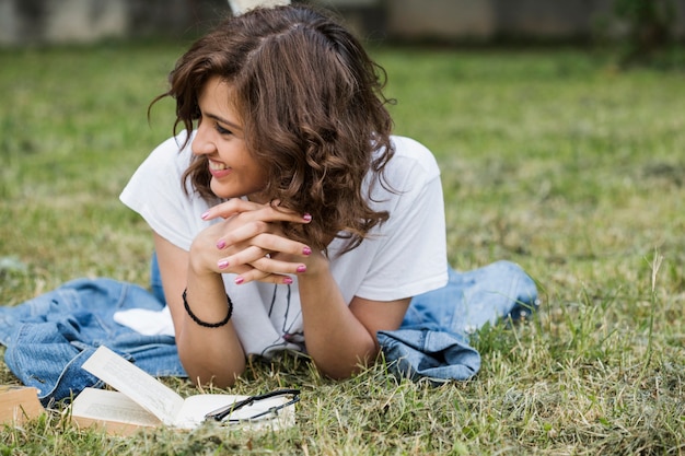 Smiling woman lying on summer grass