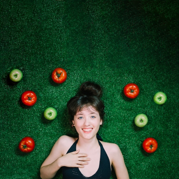 Smiling woman near apples and tomatoes