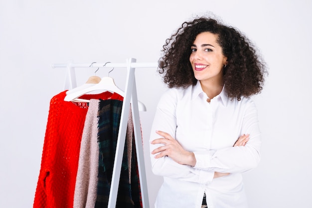 Smiling woman near clothes rack