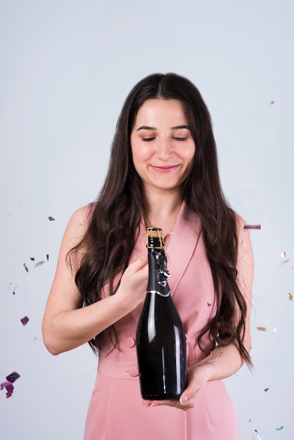 Free photo smiling woman opening bottle of champagne