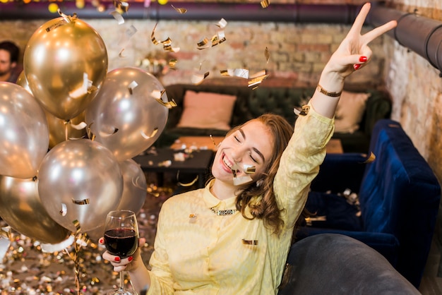 Smiling woman in party holding wine glass enjoying in party