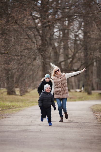 Foto gratuita donna sorridente che gioca con i suoi bambini nel parco