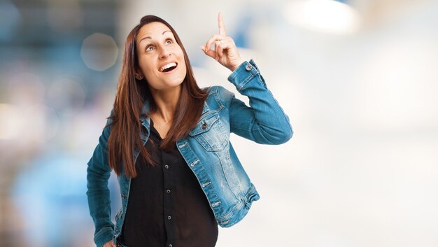 Smiling woman pointing upwards