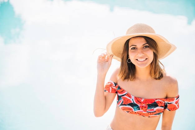 Free photo smiling woman posing in front of pool