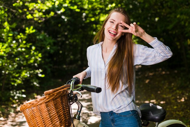 笑顔の女性が彼女の自転車でポーズ