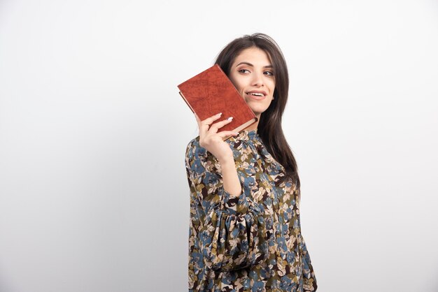 Smiling woman posing with book.