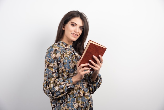 Smiling woman posing with book.