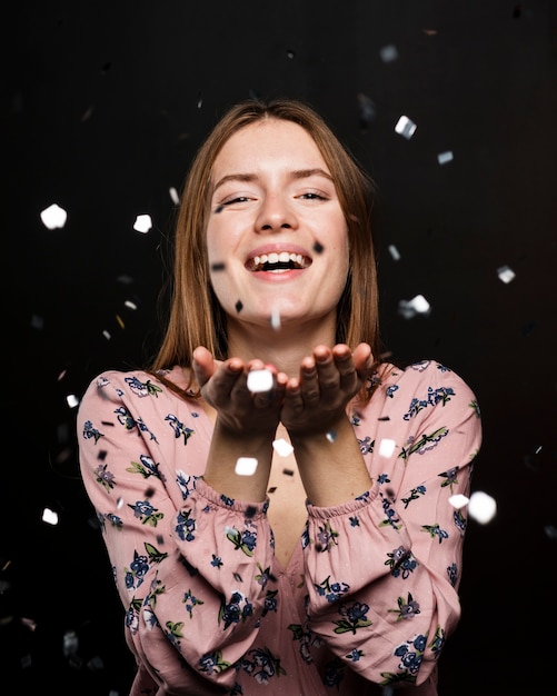 Foto gratuita donna sorridente che posa con i coriandoli