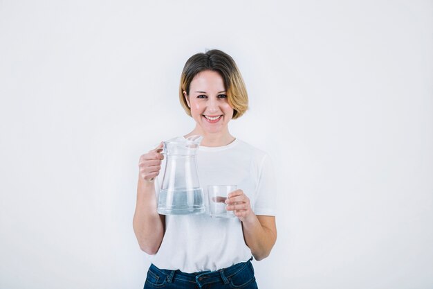 Smiling woman posing with jug and glass